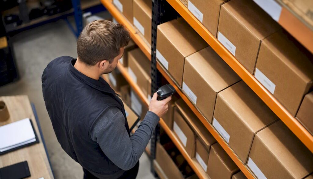 Hands scanning product barcodes in warehouse