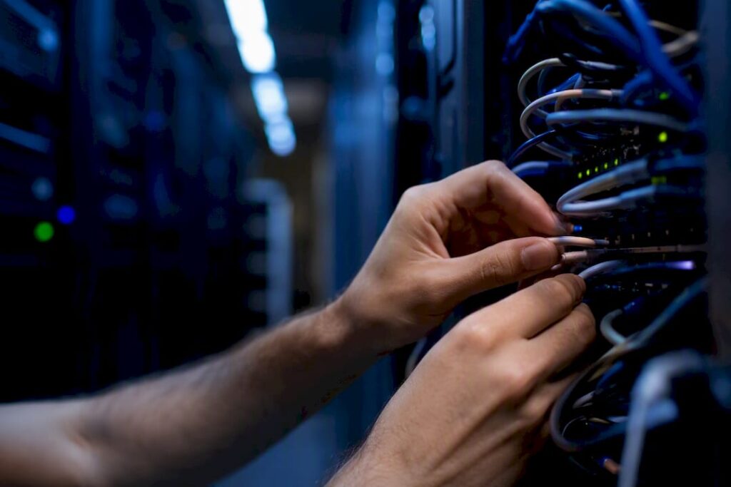 Hands working on server cables in agency rack