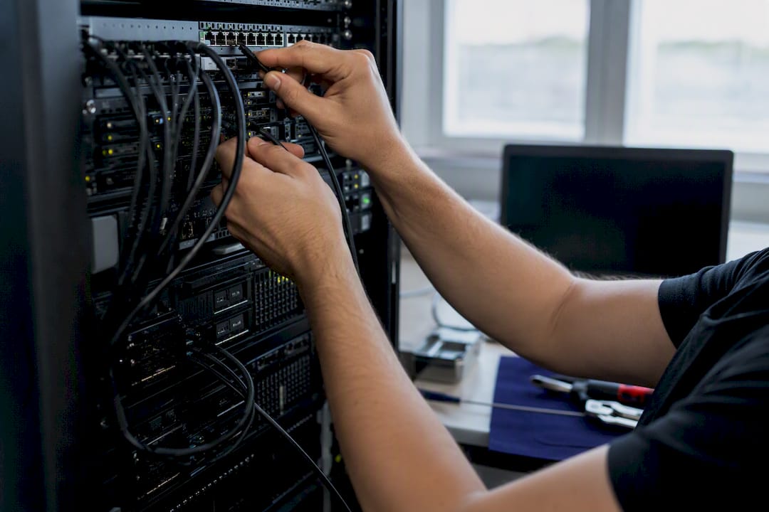 Hands tuning server cables in workspace